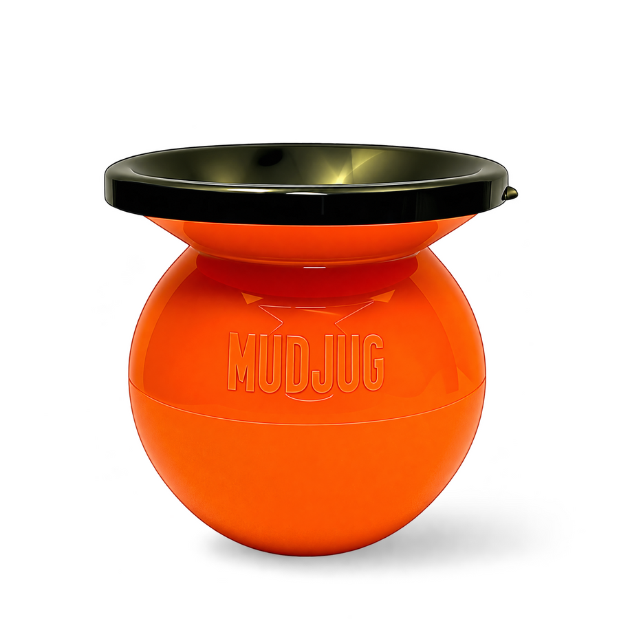 An orange spherical mud catcher with a black rim, featuring the embossed brand name 'MUDJUG' on the front, set against a plain white background.